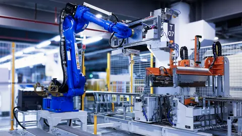 A blue industrial robot arm on a modern factory production line